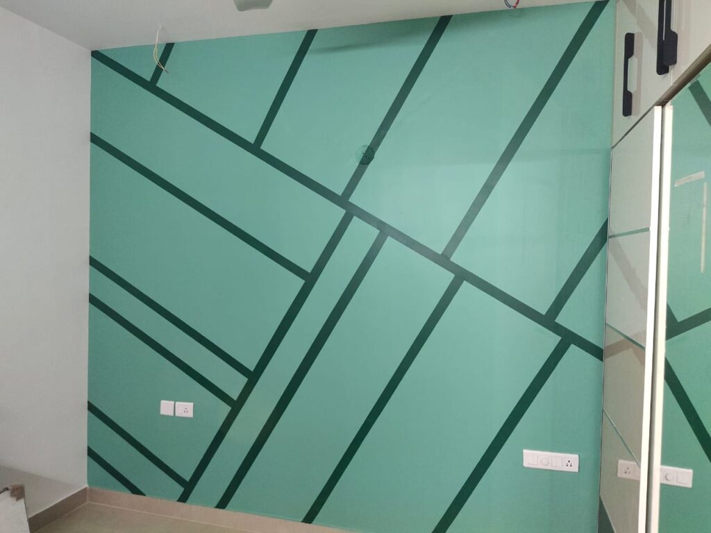 A room with a green wall painted with geometric lines.