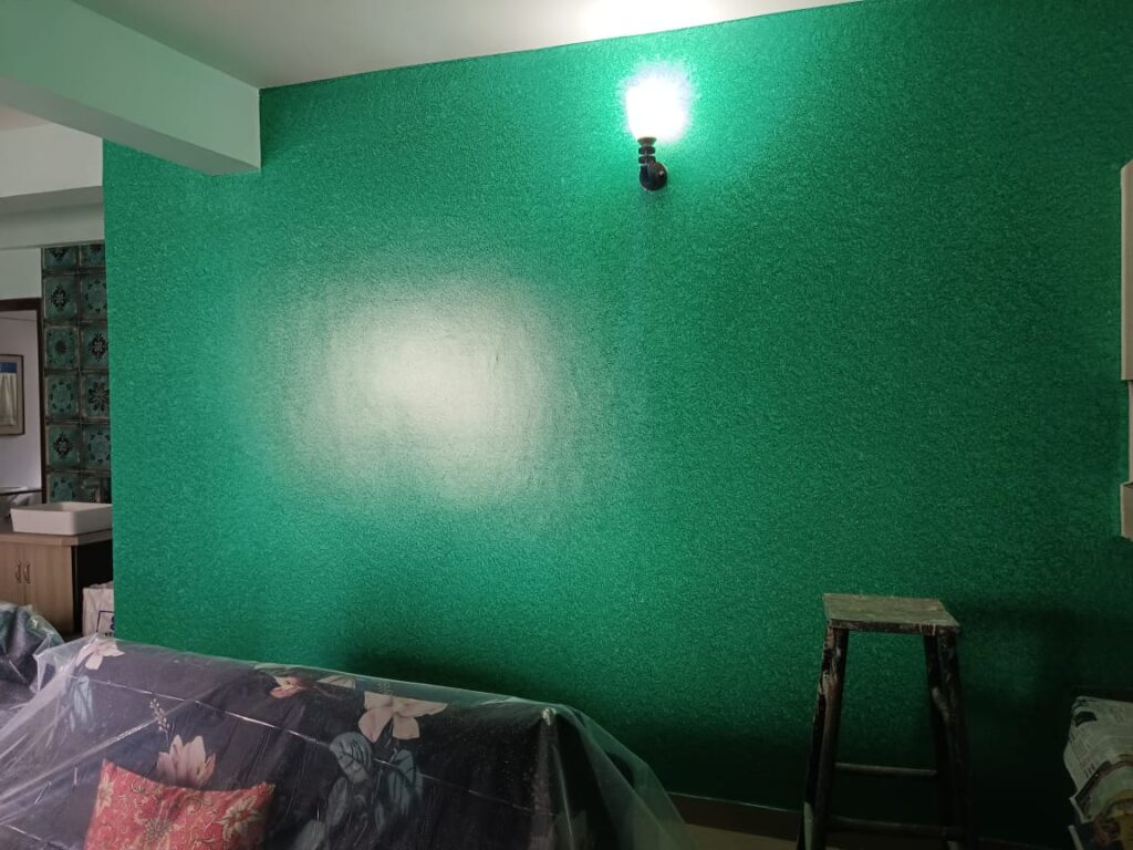 A room with green walls and a couch.