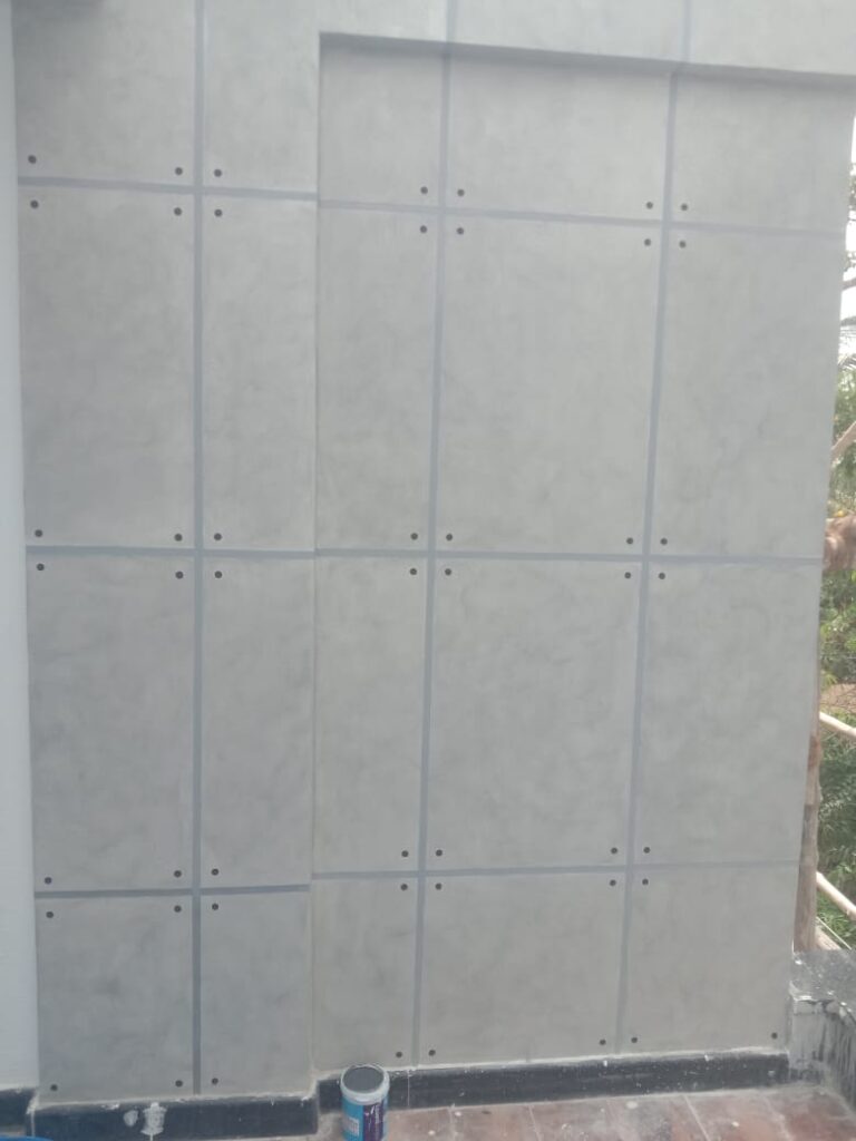 A cement board mounted on a wall with holes, showing a construction site in progress.