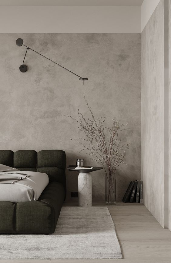 A modern bedroom with a concrete wall and a bed.